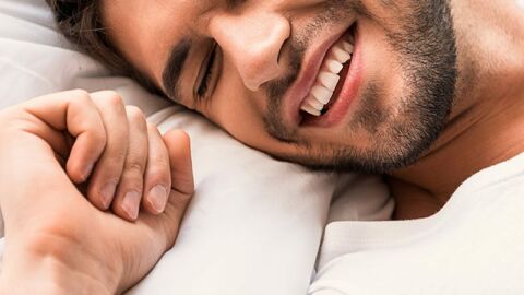 happy gay man with head on pillow