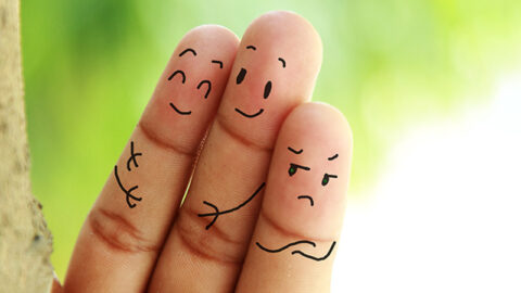 close up of three fingers with drawn on faces showing relationship jealousy